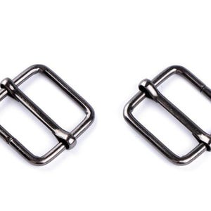 May include: Two silver-toned metal buckle closures. The buckles are rectangular with a smooth finish.