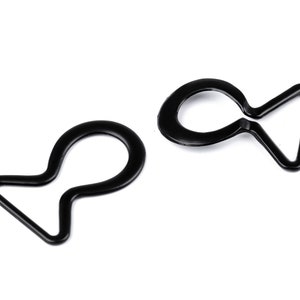 May include: Two black plastic D-ring clasps, each with a loop on one end and a triangular shape on the other.