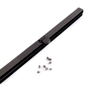 Op de afbeelding: Een zwart metalen tasframe met een drukknoop sluiting en een set kleine zilveren schroeven.