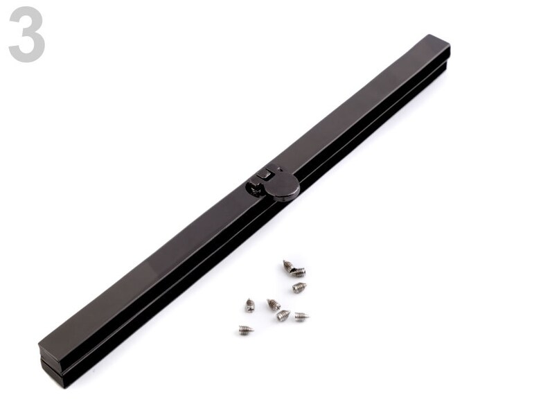 Op de afbeelding: Een zwart metalen tasframe met een drukknoop sluiting en een set kleine zilveren schroeven.