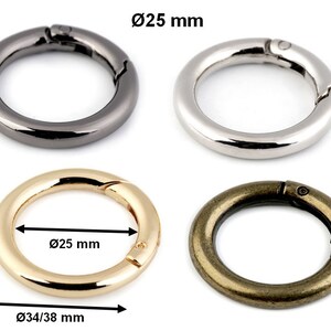 May include: Four metal key rings with a spring-loaded clasp. The rings are 25 mm in diameter and are shown in black, silver, gold, and bronze.