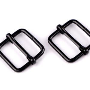 May include: Two black metal buckle closures. The buckles are rectangular with a center bar.