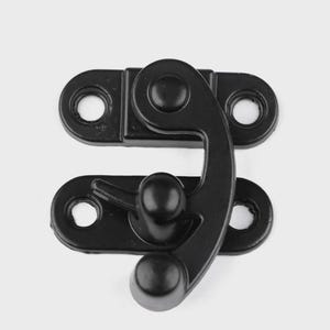 May include: A black metal clasp with a curved latch and two mounting plates, each with two holes for screws. The clasp is designed to secure a box or container.