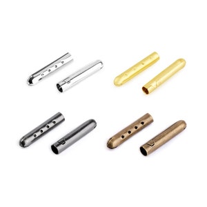 May include: Four pairs of metal cord ends in silver, gold, black, and bronze. Each pair has a pointed end and a flat end with holes.