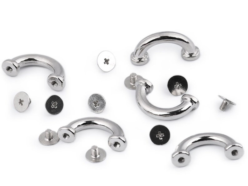 May include: A set of five silver metal D-ring hardware pieces with screws. The D-rings are curved and have a smooth finish. The screws are silver and have a cross-shaped head.