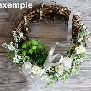 May include: A grapevine wreath decorated with white flowers, green succulents, and a white satin ribbon.