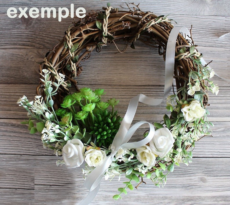 May include: A grapevine wreath decorated with white flowers, green succulents, and a white satin ribbon.
