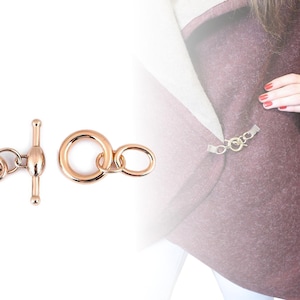 May include: Two gold-toned metal clasps for jewelry making. One clasp is a toggle clasp with a round end. The other clasp is a double ring clasp.