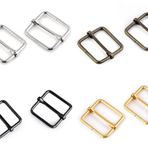 May include: Six metal buckle closures in various finishes, including silver, antique brass, black, and gold. The buckles are square shaped with a center bar.