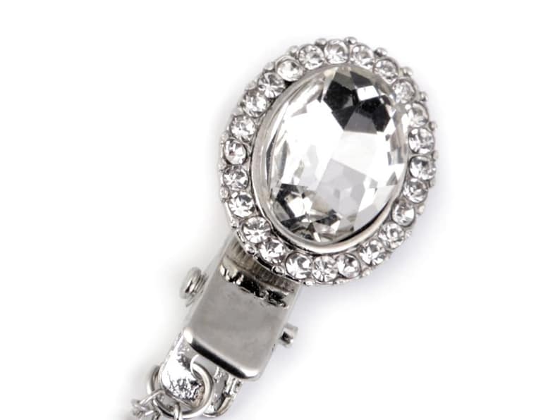May include: A silver-toned clasp with a large clear crystal surrounded by smaller crystals.