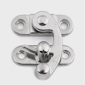 May include: A shiny, silver-colored metal clasp with a curved hook and two mounting plates, each with two holes for screws. The clasp is designed to secure a box or container.