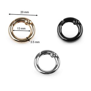 May include: Three metal key rings in gold, silver, and black. Each ring is 13 mm in diameter and 3.5 mm wide.