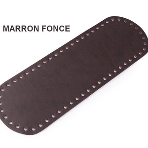 May include: A brown leather strap with holes around the edges. The text "MARRON FONCE" is printed on the strap.