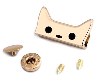 May include: Gold-toned metal cat-shaped snap fastener with two black eyes and a small nose. The snap comes with a matching stud and two screws.
