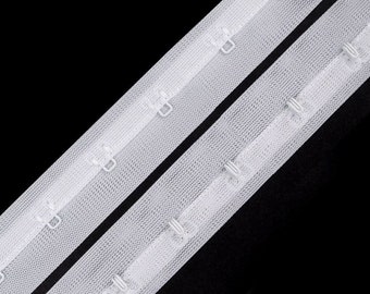 May include: White elastic bra strap with hook and eye closures. The strap is made of a soft, stretchy material and is designed to be comfortable to wear.
