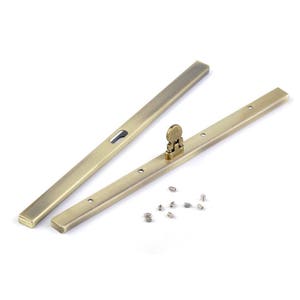 Op de afbeelding: Twee antieke gouden metalen schuifdeurbeslag met een klein metalen slot en een set schroeven.