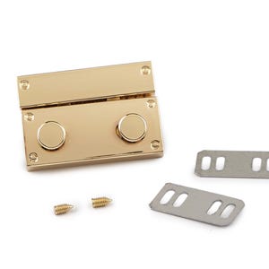 Può includere: Una chiusura rettangolare color oro con due pomelli rotondi e quattro viti. Sono incluse anche due piastre metalliche argentate con fori ovali. Questo hardware è probabilmente per borse o altri accessori.