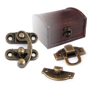 May include: Four antique brass box clasps. Two are hinged with a latch, one is a simple hook and eye, and the last is a small, round knob with a decorative plate.