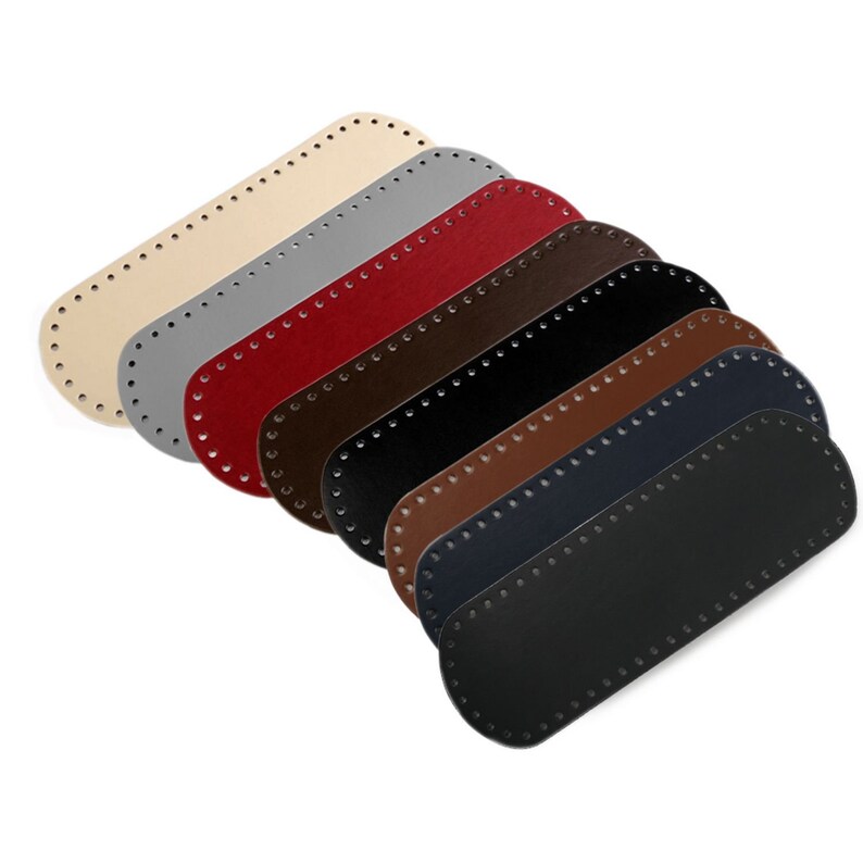 May include: Seven oval-shaped leather pieces with stitched edges in various colors: beige, gray, red, brown, dark brown, navy blue, and black.