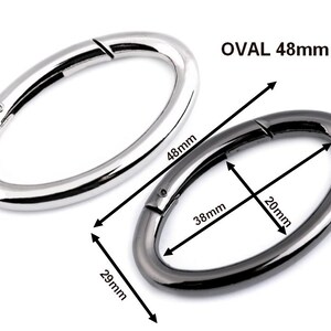 May include: Two oval-shaped metal clasps, one silver and one black. The silver clasp is 48 mm long and the black clasp is 48 mm long, 20 mm wide, and 29 mm high.  OVAL 48mm.