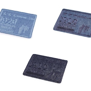 Peut inclure: Trois patchs en denim avec le texte "1924 Historical Climbers" en broderie blanche. Les patchs sont rectangulaires et ont un aspect denim vieilli.