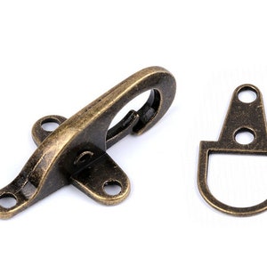 May include: Antique brass swivel hook and D-ring clasp. The hook has a spring-loaded latch and three holes for attaching to a strap or belt. The D-ring has two holes for attaching to a strap or belt.