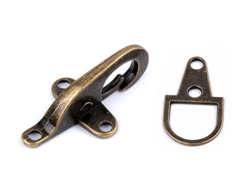 May include: Antique brass swivel hook and D-ring clasp. The hook has a spring-loaded latch and three holes for attaching to a strap or belt. The D-ring has two holes for attaching to a strap or belt.