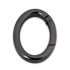 May include: Black metal swivel clasp ring. The ring is oval shaped and has a smooth finish.