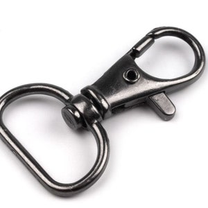 May include: A black metal swivel hook with a D-ring. The hook is closed and ready to be attached to a bag, keychain, or other item.