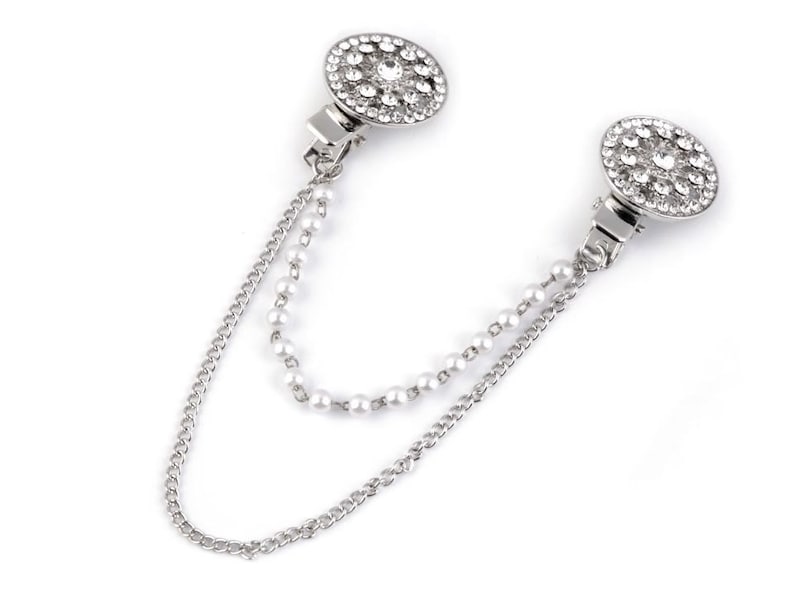 May include: A silver chain with two round, rhinestone-encrusted clasps. The chain is made of two strands, one with small pearls and one with a more traditional chain link.