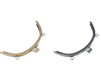 Puede incluir: Dos marcos de bolso de metal, uno dorado y otro negro, con detalles decorativos y cierre de broche.
