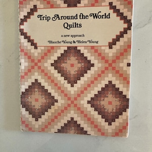 May include: A softcover book titled Trip Around the World Quilts, a new approach by Blanche Young & Helen Young. The cover features a repeating geometric diamond pattern in shades of brown, tan, and coral, with a white rectangular centre.