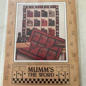 May include: A paper pattern titled CRAZY FOR CATS by MUMM'S THE WORD featuring illustrations of two patchwork quilts with cat motifs, black cat figurines in a basket, and a border of small cat faces. The document includes a Spokane, WA address.