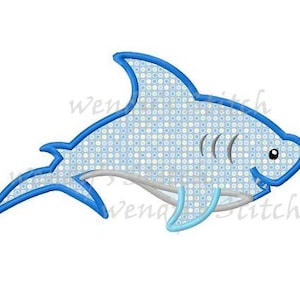 Puede incluir: Aplique de tiburón bordado en azul y blanco con un patrón de puntos.