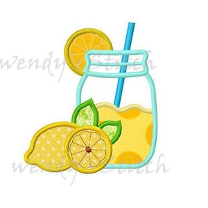 May include: A blue mason jar with a yellow straw filled with lemonade. There are two lemons and a slice of lemon next to the jar.