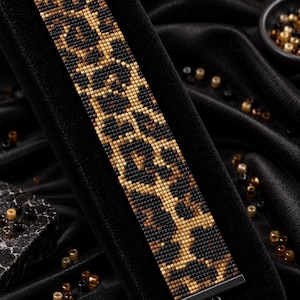 May include: A beaded bracelet featuring a brown and black leopard print pattern. The text reads Bracelet Bead Pattern, PDF, Instant Download, LOOM STITCH, Miyuki Delica 11/0, Color Chart, and Word Chart. The bracelet has black metal end bars.
