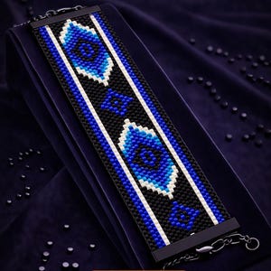 May include: A beaded bracelet pattern with a blue and white geometric design on a black background. The text "Bracelet Bead Pattern" and "PDF • Instant Download" are displayed at the top. The text "PEYOTE STITCH" is also visible.