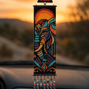 Puede incluir: Un adorno rectangular de cuentas para coche con un retrato de elefante en tonos naranja, azul cerceta y negro. La pieza está rematada con un pequeño triángulo de cuentas y siete hilos colgantes de cuentas de cristal multicolor en la parte inferior.