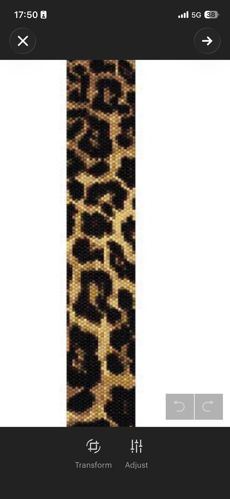 May include: A long, narrow, rectangular strip featuring a repeating leopard print pattern composed of small, individual beads. The design consists of black, dark brown, and tan spots arranged in a dense, textured grid across the entire surface.
