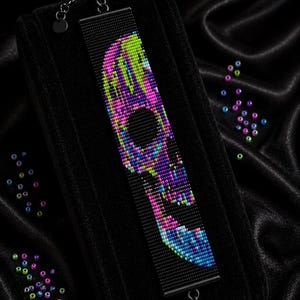Puede incluir: Una pulsera rectangular tejida en telar con un patrón de calavera multicolor vibrante en cuentas verde neón, rosa y azul sobre un fondo negro. El texto dice Bracelet Bead Pattern, PDF, Instant Download, Loom Stitch, Miyuki Delica 11/0, Color Chart, Word Chart.