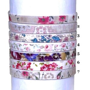 May include: Seven different fabric headbands with floral patterns in various colors, including pink, blue, purple, and white. The headbands are stacked on top of each other, with the numbers 1 through 7 next to them.