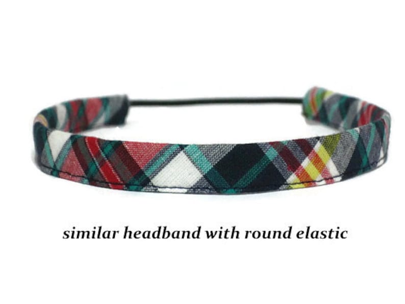 May include: A plaid headband with a black, red, green, and white pattern. The headband has a thin black elastic band.