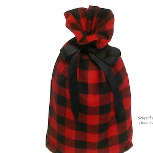 May include: Red and black plaid gift bag with a black ribbon. Several sizes and ribbon colors are available.