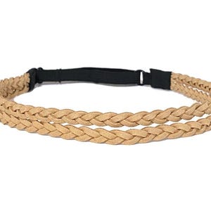 May include: A tan braided headband with a black elastic band. The headband features two rows of braided material, creating a textured and stylish accessory. The neutral color makes it versatile for various outfits.