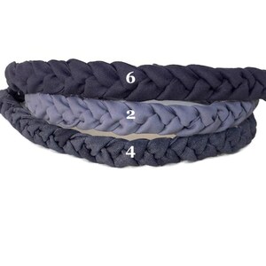 May include: Three braided headbands stacked vertically. The top headband is dark charcoal gray with the number 6, the middle is light slate blue with the number 2, and the bottom is dark navy blue with the number 4 printed in white on each.