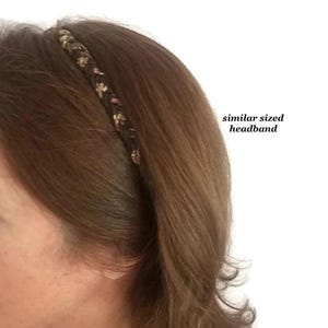 May include: A thin, braided headband featuring a dark brown base with interwoven light brown and tan accents. The accessory is positioned on brown hair, with text to the right reading similar sized headband, indicating the scale of the item.