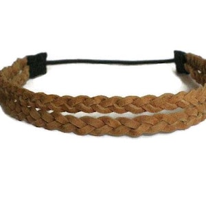 May include: A brown braided headband with a black elastic band. The headband features two rows of braided material, creating a textured and stylish accessory. The neutral color makes it versatile for various outfits.
