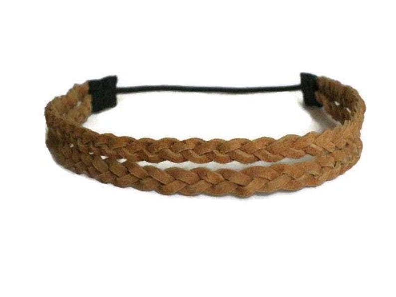 May include: A brown braided headband with a black elastic band. The headband features two rows of braided material, creating a textured and stylish accessory. The neutral color makes it versatile for various outfits.