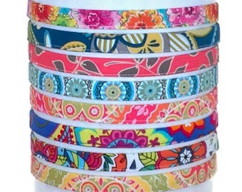 May include: A stack of colorful fabric headbands with various floral and geometric patterns. The headbands are made of soft, stretchy fabric and are perfect for adding a pop of color to any outfit.