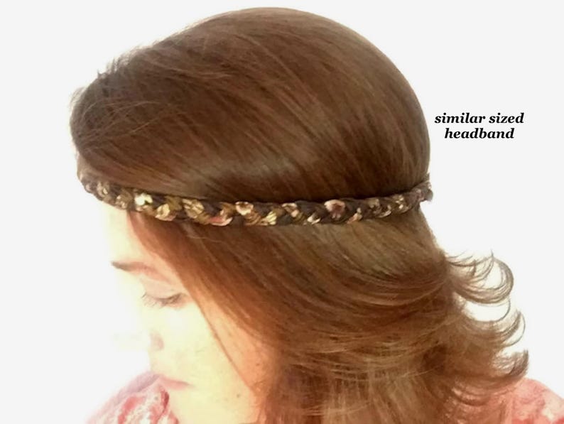 May include: A braided headband featuring a mix of dark brown, tan, and metallic gold tones. The headband is worn around the head, and the text "similar sized headband" is printed in black on the right side of the image.
